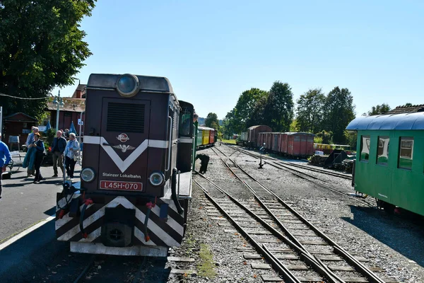 Stainz, Avusturya - 23 Eylül 2021: Flascherlzug denilen vagonların renkli vagonları - şişe treni - dar çaplı bir demiryolu ve Batı Styria 'da popüler bir turistik eğlence merkezi, dizel lokomotifte bilinmeyen motor sürücüsü