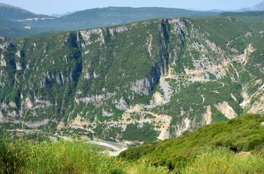 Yunanistan, Arachtos nehri üzerinde eski ve yeni bir köprü ve Tzoumerka- Peristeri- Arachthos Vadisi ve Acheloos Vadisi 'ndeki son derece dolambaçlı bir dağ yolu.
