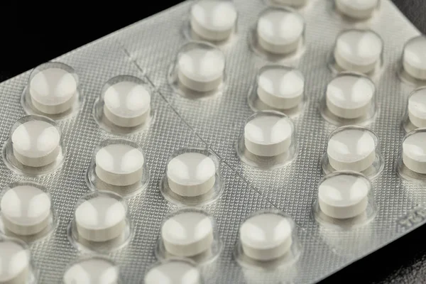 Beyaz haplar siyah arka planda izole edilmiş.