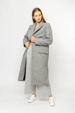 Beyaz arka planda izole edilmiş gri ceketli bir kız.