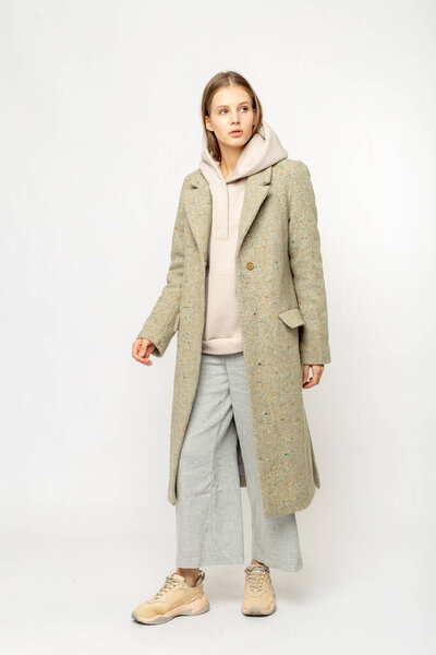 Девушка в бежевом пальто на белом фоне