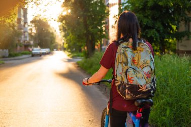 Kırsal bir yolda bisikletli genç bir bayan.