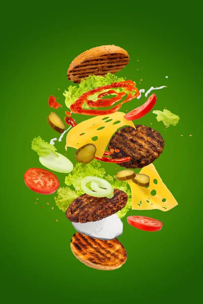 Velký Chutný Hamburger Létajícími Prvky Létající Burger Zelené Pozadí — Stock fotografie
