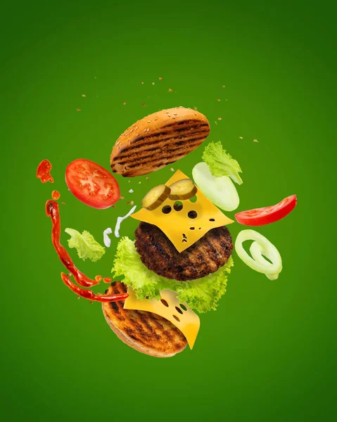Velký Chutný Hamburger Létajícími Prvky Létající Burger Zelené Pozadí Dvojitý — Stock fotografie