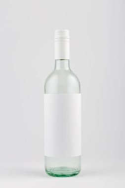 Transparent white wine bottle with blank white label on white background, mock up.