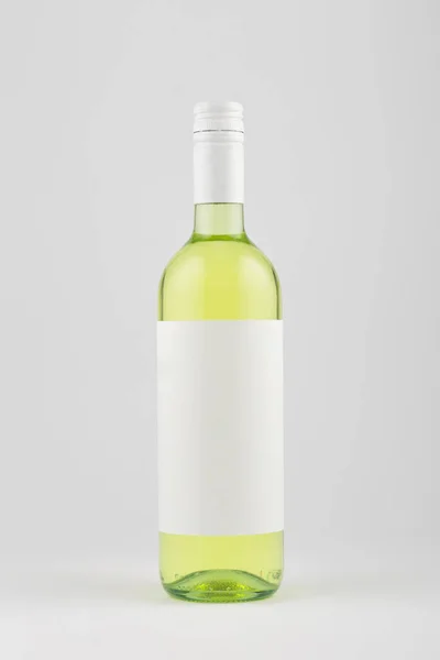 White wine bottle with blank white label on white background, mock up.