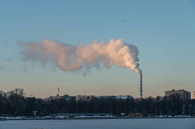 Soğuk bir akşamda bacadan duman ve buhar çıkar.