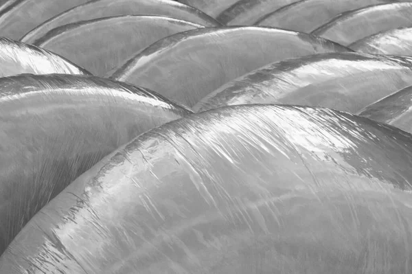 Faded black and white background of plastic wrapped hay bales