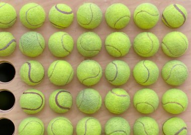 Ahşap çerçevede üç topun eksik olduğu kullanılmış tenis toplarının arka planı