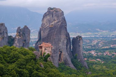 Dik bir uçurumun tepesindeki Rousanou Manastırı manzarası. Meteora 'nın mucizesi: İnsanoğlunun ve doğanın Yunanistan' daki uyumu. Popüler bir seyahat ve hac mekanı.