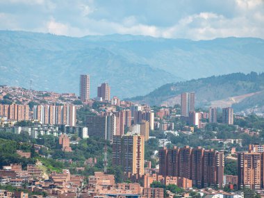 Medellin şehrinin manzarası, binalar, dağlarla çevrili ağaçlar güneşli bir günde