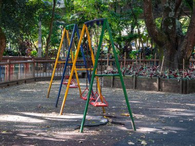 Güneşli bir günde Medellin Parkı 'nda İki Renkli Renkli Salıncak