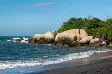 Deniz Dalgaları 'nın manzarası Tayrona Park, Kolombiya' da bolca köpükle birlikte kıyıya doğru geliyor.
