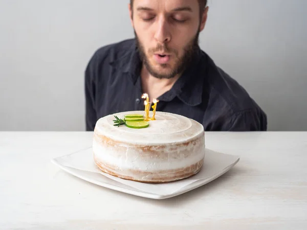 Homem Branco Sopra Velas Amarelas Bolo Aniversário Vegan Com Amêndoa — Fotografia de Stock