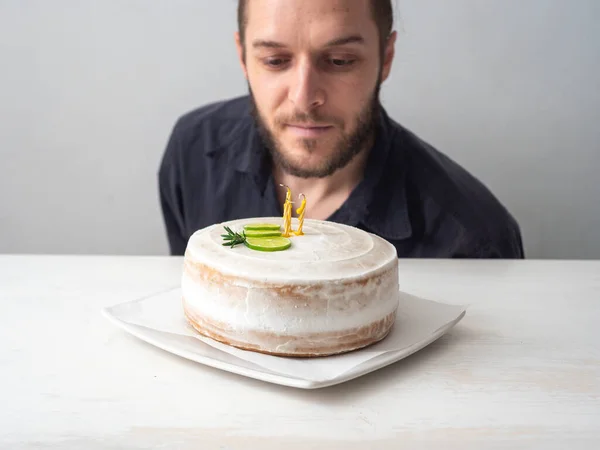 Homem Branco Olha Velas Amarelas Bolo Aniversário Vegan Com Amêndoa — Fotografia de Stock