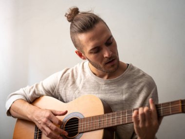 Beyaz Adam Beyaz Arkaplan ile Akustik Gitar Çalıyor