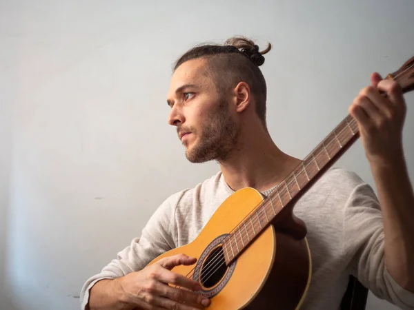White Man Plays Acoustic Guitar with a White Background