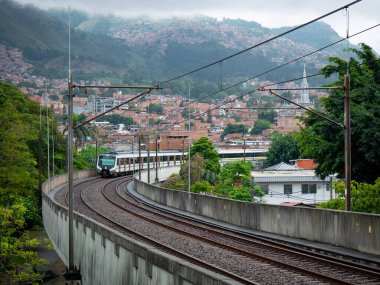 Şehrin arka planıyla Demiryolu 'ndan geçen metro.