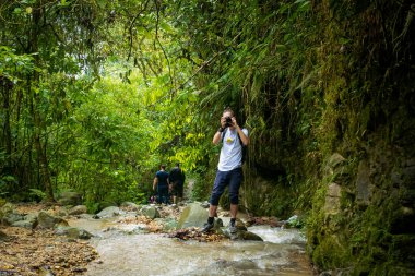 Beyaz adam doğanın ortasında fotoğraf çekiyor ve üzerinde leopar ve 