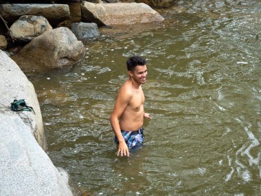 Güney Amerikalı Adam Nehrin Soğuk Suyuna Giriyor Etrafı Kayalarla çevrili