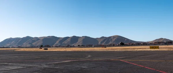 Airstrip with a View of the Mountains, the Dry and Yellow Soil in Contrast to a Beautiful Clear Blue Sky