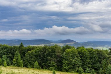 Dağın tepesinde muhteşem bir manzara. Güneşle aydınlanan dağ vadilerinin panoramik manzarası