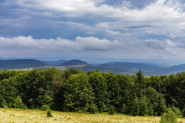 Dağın tepesinde muhteşem bir manzara. Güneşle aydınlanan dağ vadilerinin panoramik manzarası