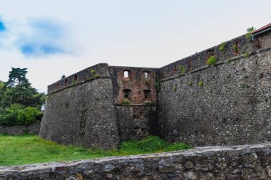 Antik Uzhgorod şatosunun önünde yeşil bir çimenlik olan Ortaçağ Gri Kale duvarı. Uzhgorod Kalesi, Zakarpattya Bölgesi, Batı Ukrayna