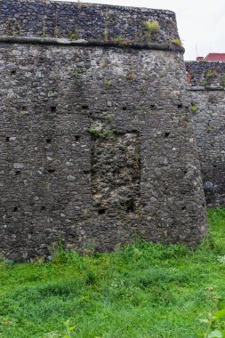 Antik Uzhgorod şatosunun önünde yeşil bir çimenlik olan Ortaçağ Gri Kale duvarı. Uzhgorod Kalesi, Zakarpattya Bölgesi, Batı Ukrayna