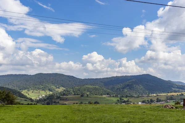 カルパティアの山の牧草地 谷や芝生の丘と田舎の夏の風景 明るい青空にふわふわの雲 自然の新鮮さコンセプト — ストック写真