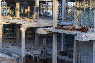 Göl kıyısında mavi gökyüzüne karşı yapım aşamasında olan vinç ve bina