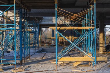 Göl kıyısında mavi gökyüzüne karşı yapım aşamasında olan vinç ve bina