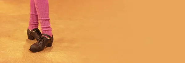 Sert ayakkabılı İrlandalı dansçı pankartı ve ahşap zeminde mor taytlar, fotokopi alanı ile kapatılmış bacaklar.