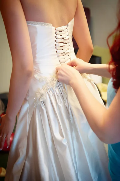 Bridesmaid tightening bride corset — Stock Photo, Image