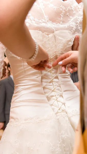 Bridesmaid tightening bride corset — Stock Photo, Image