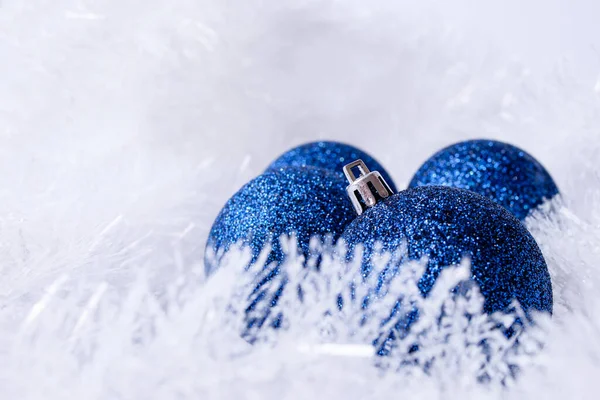 Beyaz tüylü arka planda mavi Noel süslemeleri yakın çekim