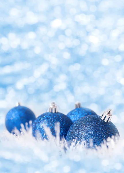Işıltılı arka planda Mavi Noel Baloları