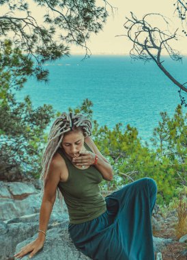 Rastafarian kızı Akdeniz kıyısında sigara içiyor.. 