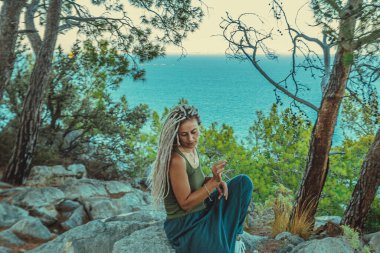 Rastafarian kızı Akdeniz kıyısında sigara içiyor.. 