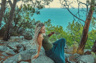 Rastafarian kızı Akdeniz kıyısında sigara içiyor.. 