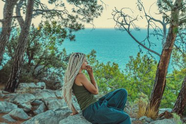 Rastafarian kızı Akdeniz kıyısında sigara içiyor.. 