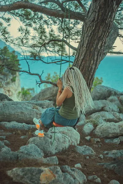 Rasta saçlı kız Akdeniz kıyısında bir salıncakta dinleniyor.. 