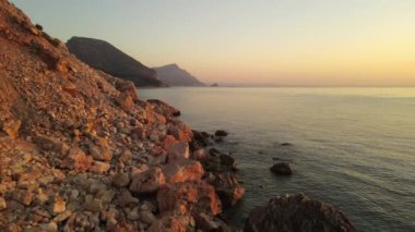 Akdeniz 'in kayalık kıyıları şafak vakti. 4k görüntü