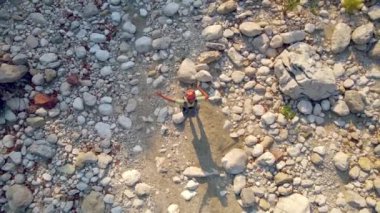 Adam kurumuş bir nehrin yatağında yürüyor.