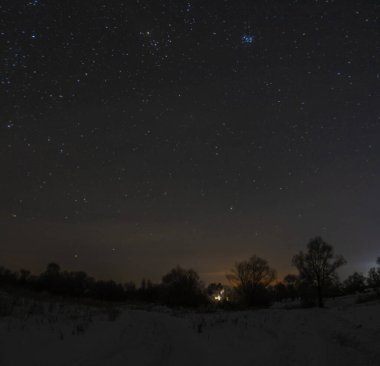 Geceleri yıldızların altında, kışın köy. 