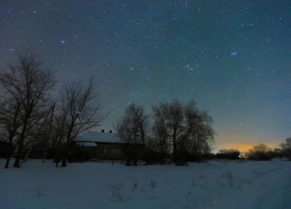 Geceleri yıldızların altında, kışın köy. 