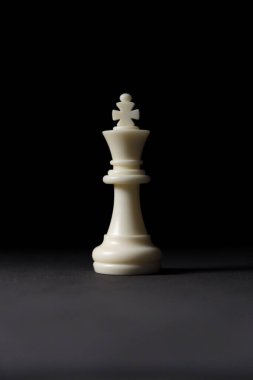 Siyah arkaplanda beyaz kral satranç taşı