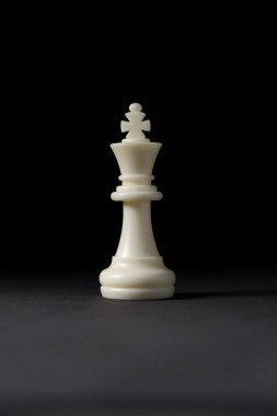Siyah arkaplanda beyaz kral satranç taşı