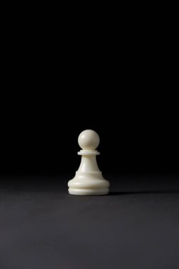 Siyah arkaplanda izole edilmiş beyaz piyon satranç taşı