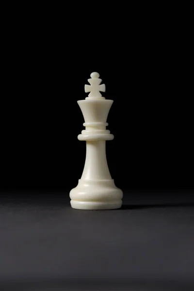 Siyah arkaplanda beyaz kral satranç taşı